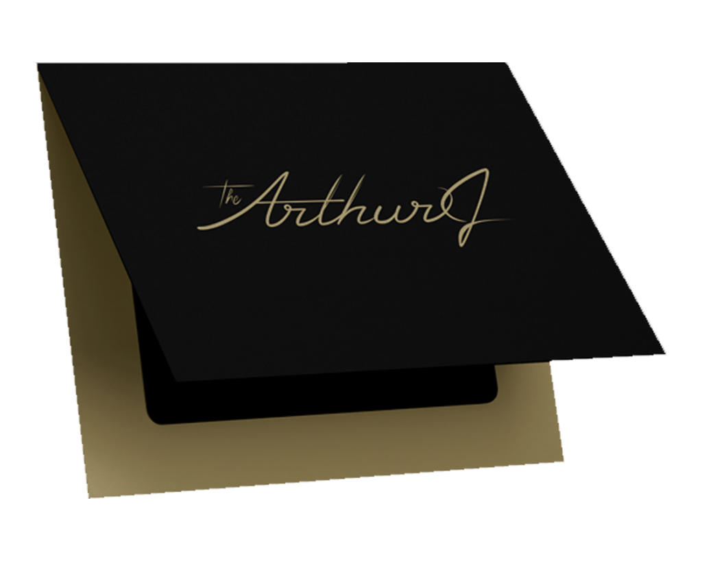 A black The Arthur J gift card with gold script lettering resting on a gold envelope.