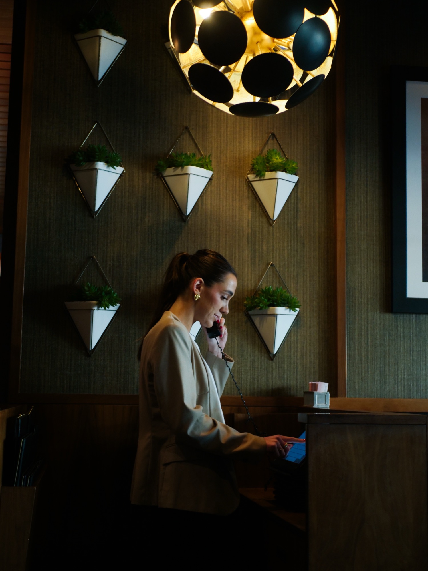 A host welcoming guests at the reservation desk at The Arthur J